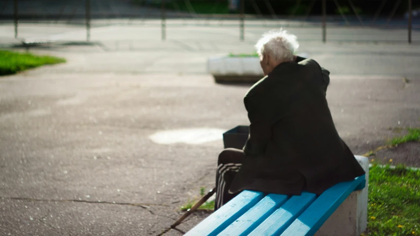 an old lady is sitting on a bench