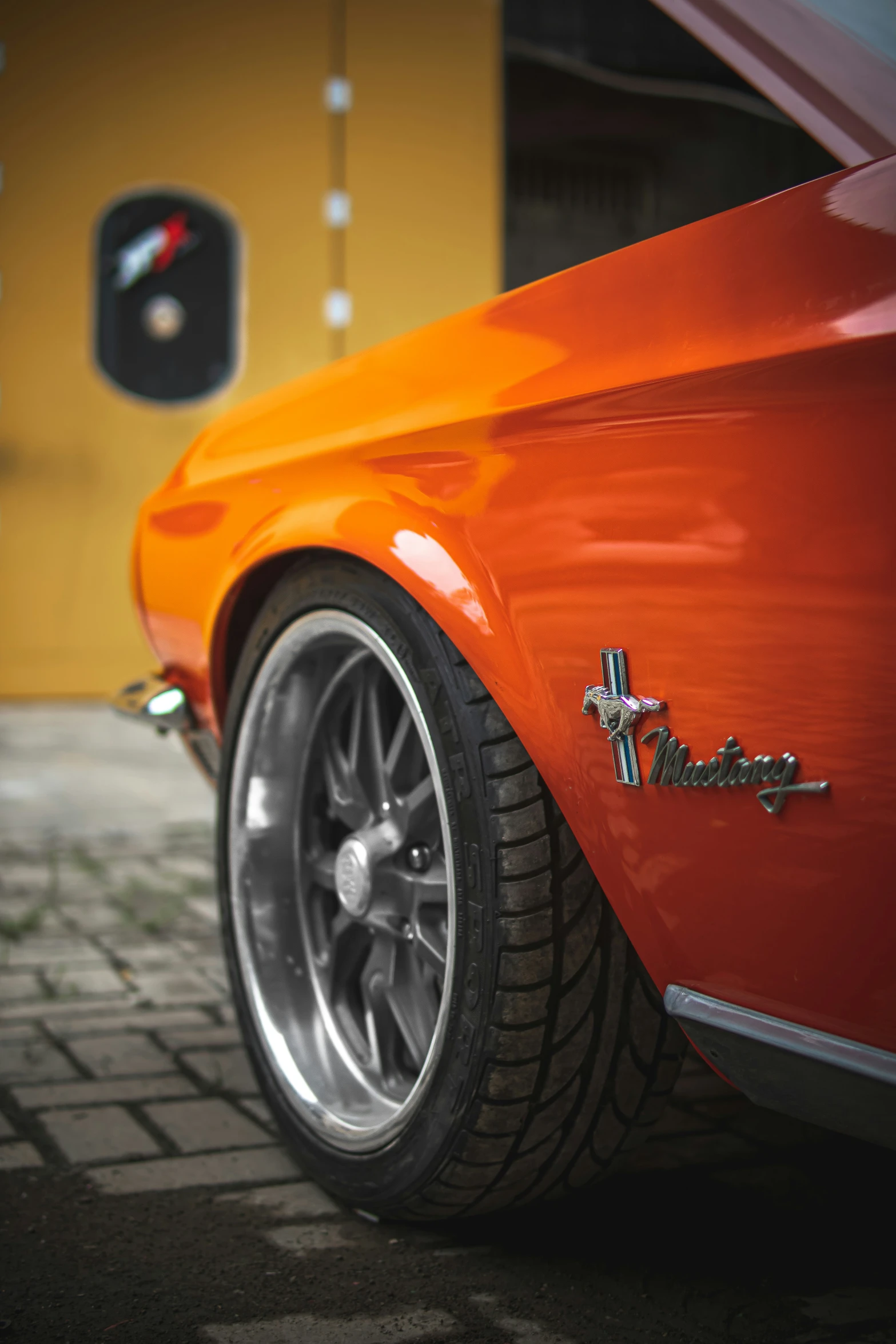 a close up of the tire on an orange mustang