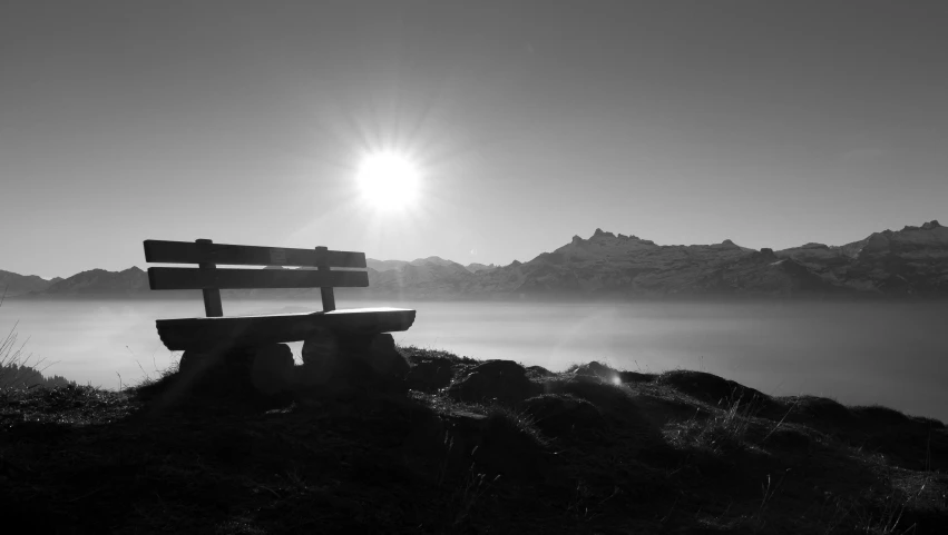 a bench that is on a hillside under the sun