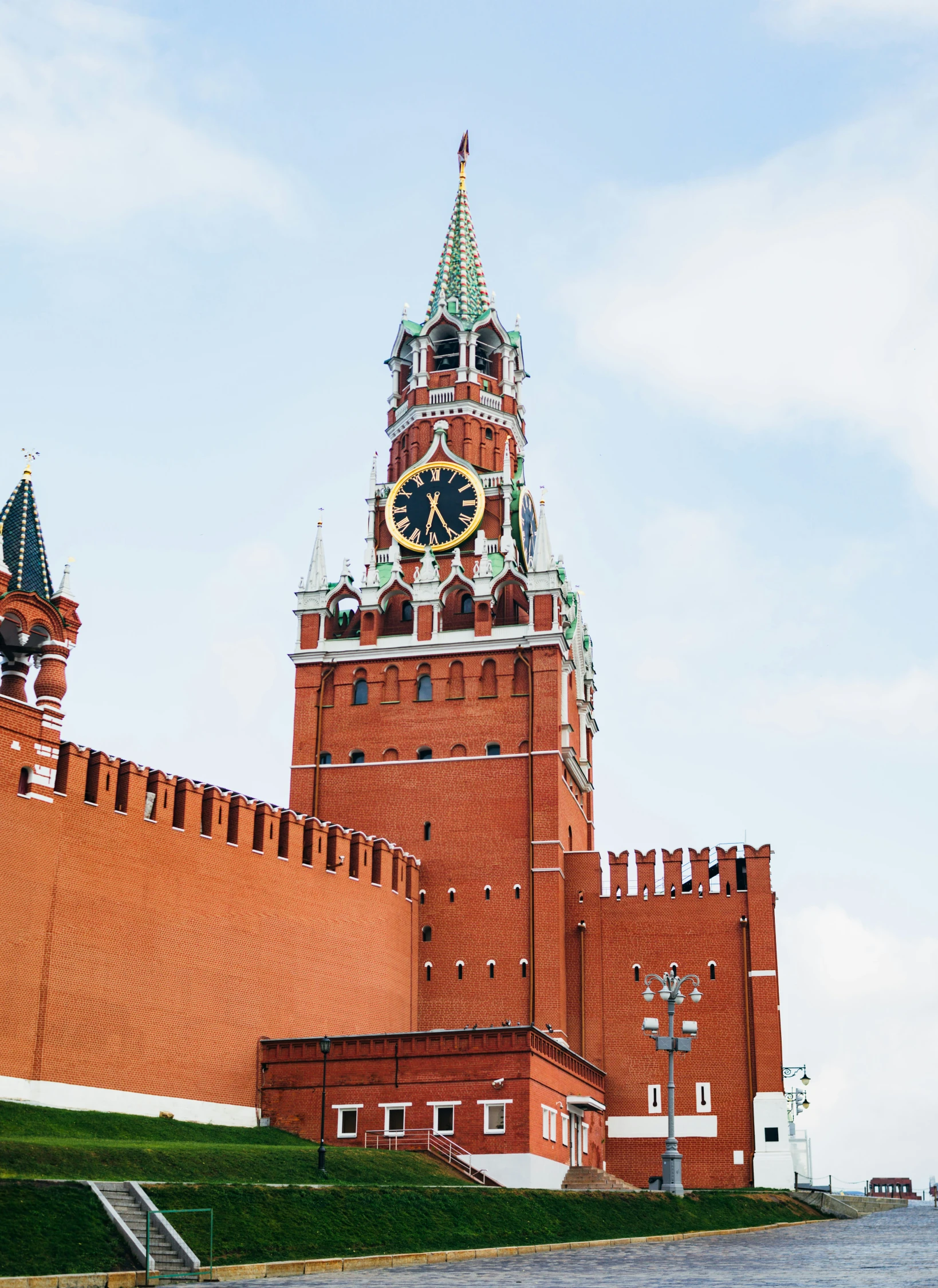 a clock tower is surrounded by two red brick structures