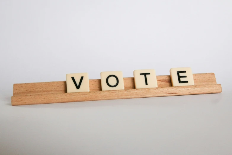 wooden scrabble blocks spelling out the word vote