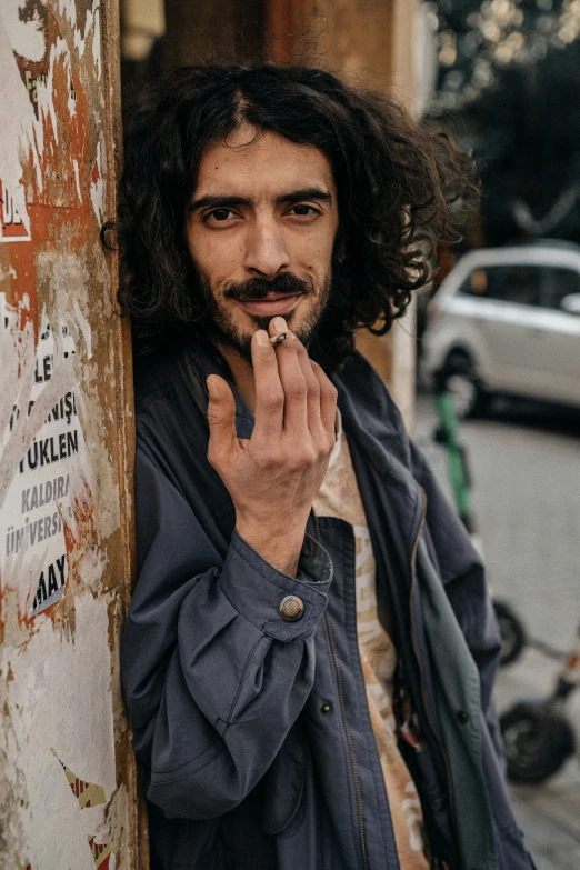 a man leaning against the side of a building