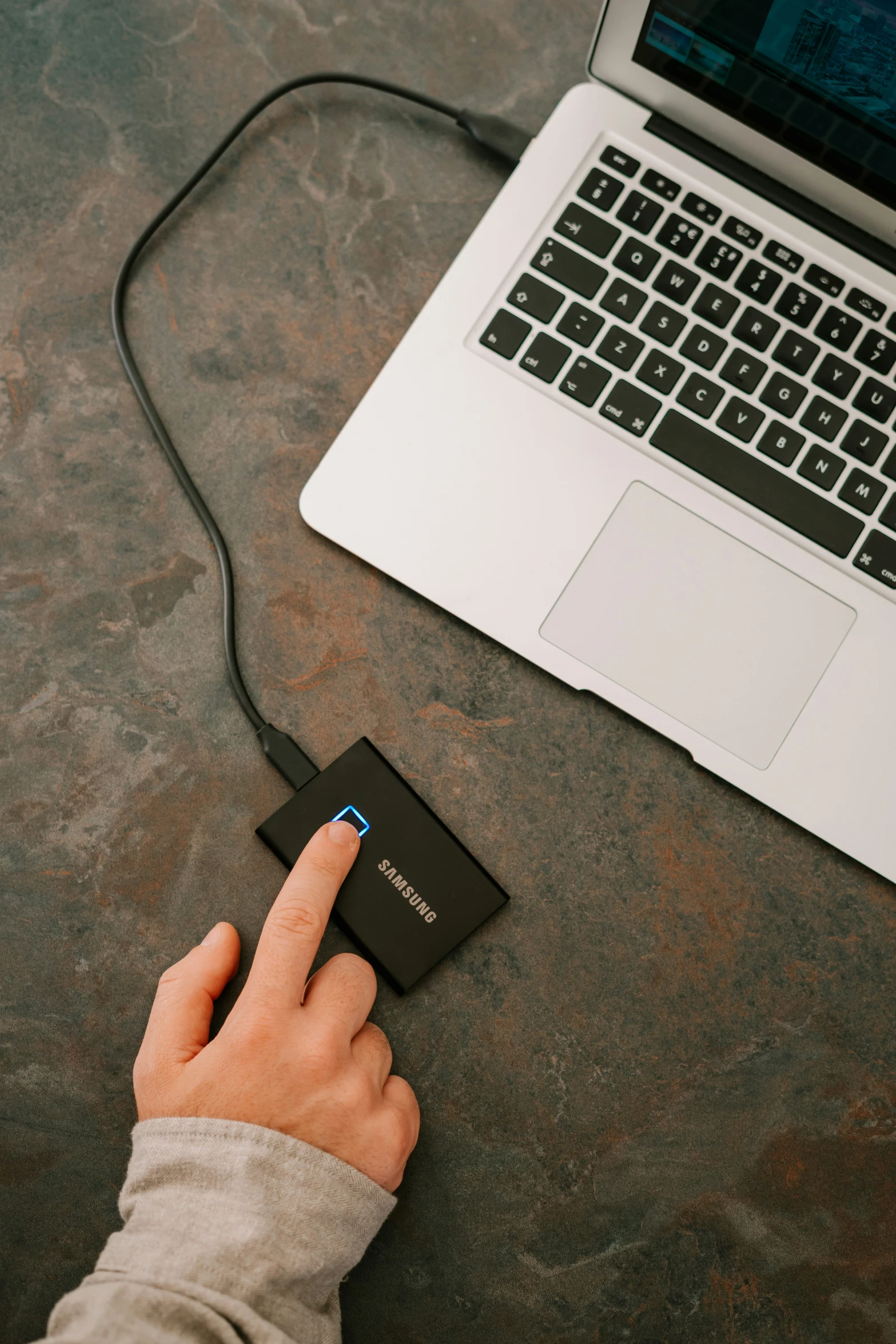 the hand is pressing a small square item on a computer