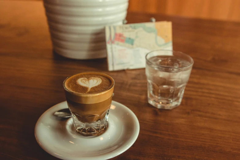 the table has two cups on it and one is filled with liquid