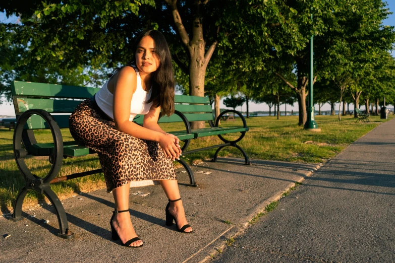 a woman sitting on a bench by the water