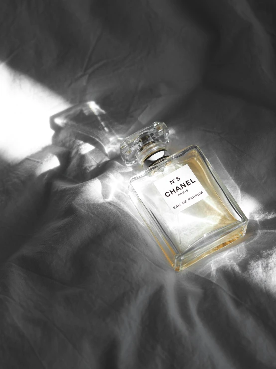 a small bottle of eau parfum sitting on a blanket