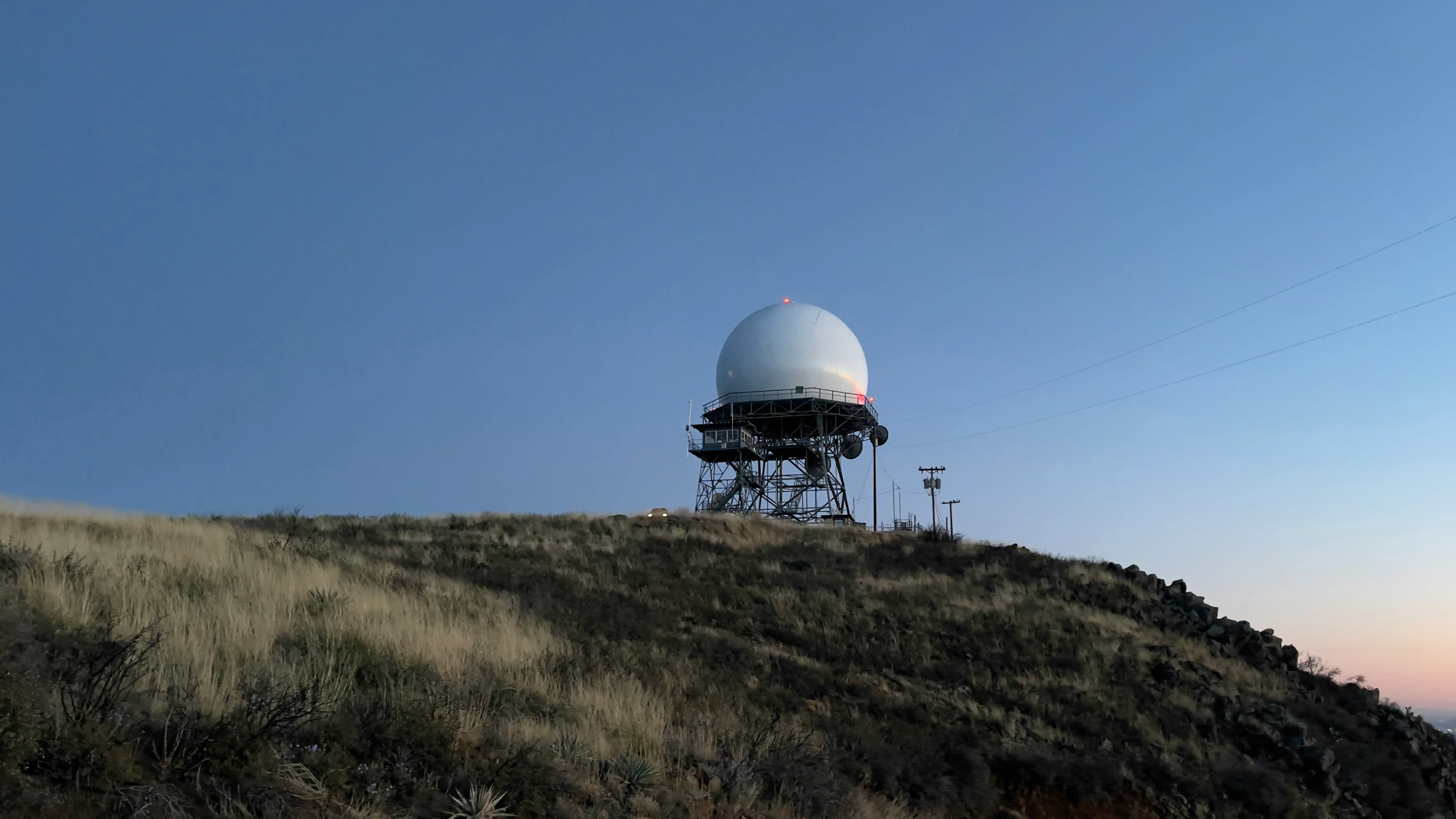 a large white dome sits on the side of a hill