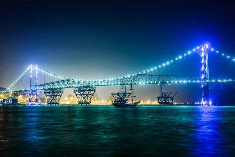 a large long bridge over the water with lots of lights on it