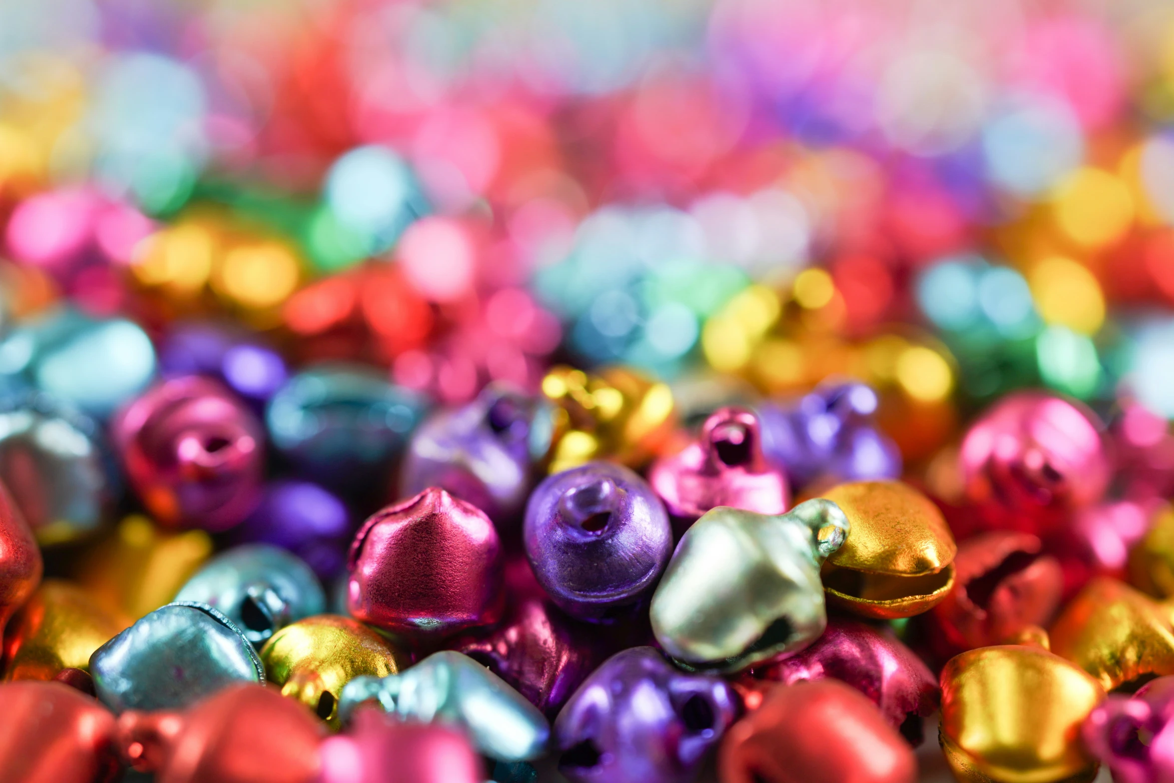 colorful metallic ornaments with gold bells in a pile