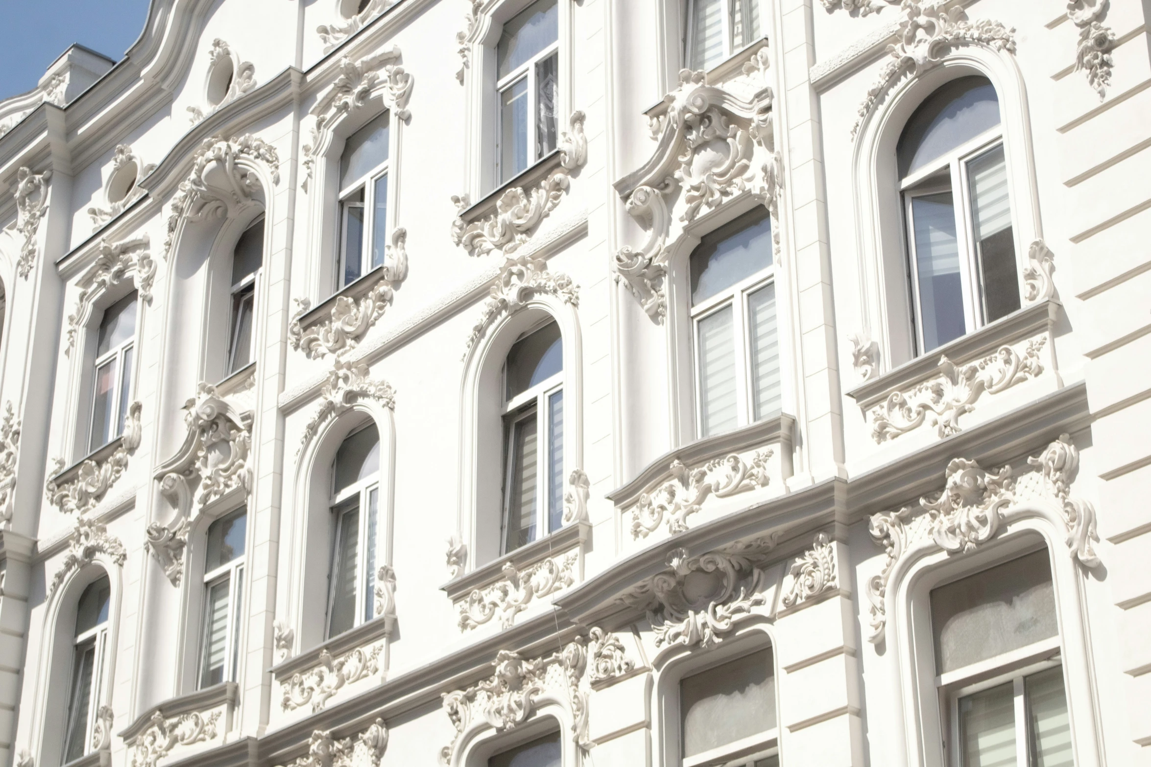 a white building with windows in it next to a clock