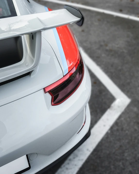 a white car with an orange tailpipe parked in the parking lot