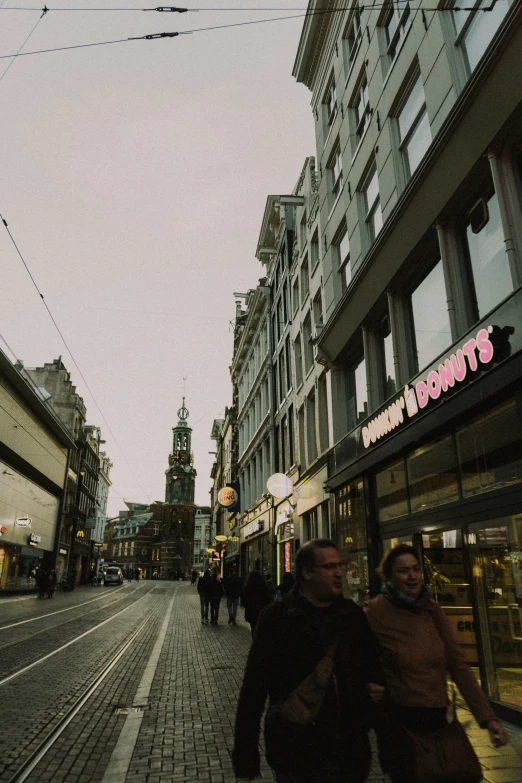 a street lined with tall buildings and people walking