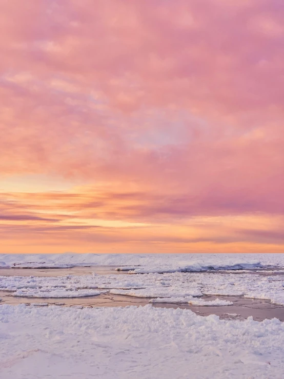 a pink sunset and pink clouds on the beach