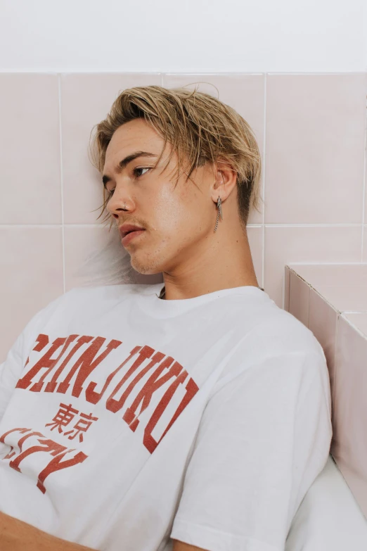 a man sitting in front of a tile wall