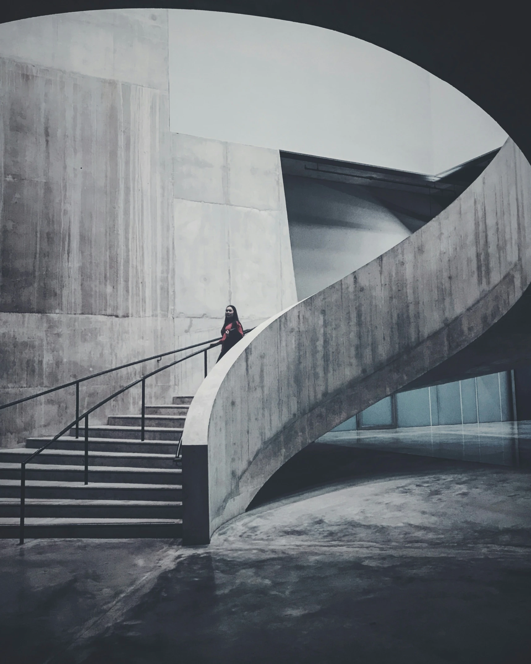 a woman is sitting on the edge of stairs while looking at her phone