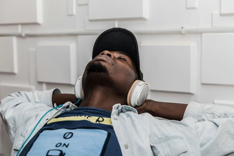 a man resting down with headphones on his ears