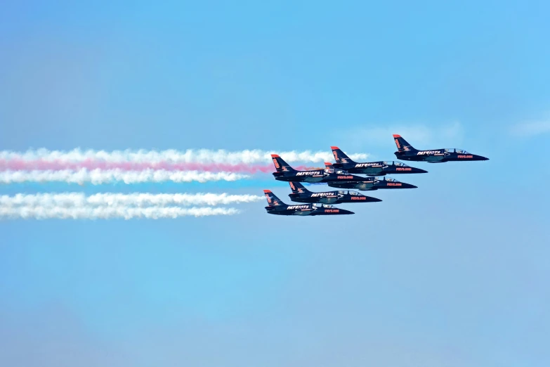 four airplanes are flying in formation with a blue sky behind them