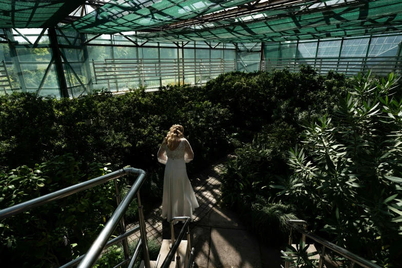 a woman in a white dress walking up some steps