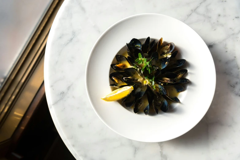 the mussels are served in a white bowl on the table