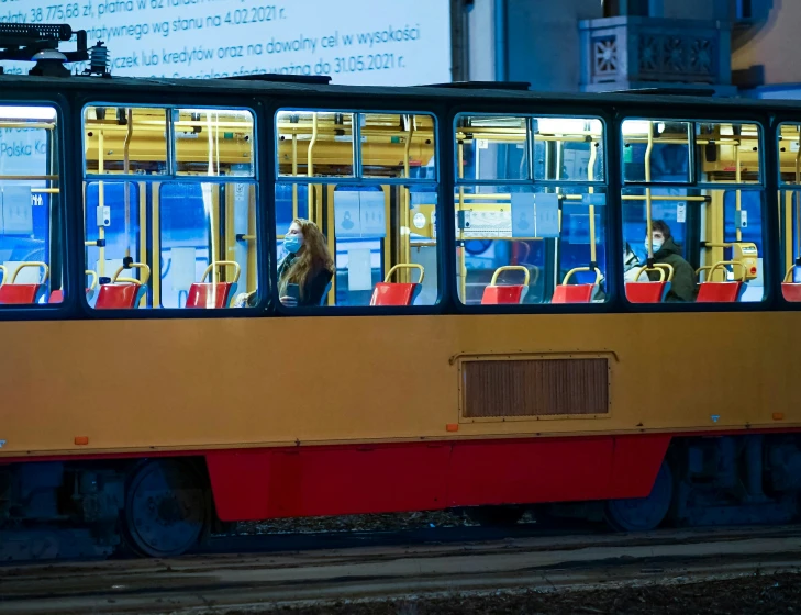 a yellow and red trolly going down a track