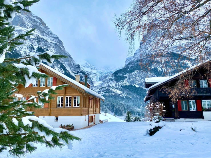 a mountain scene with a snow covered road and a cabin