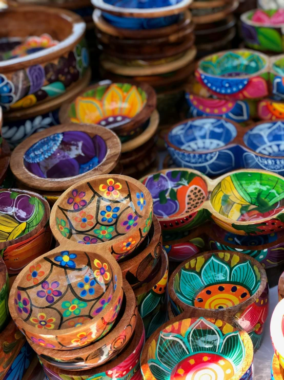 many colorful bowls stacked together with one lid open