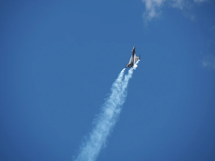 jet that is flying through the sky with smoke