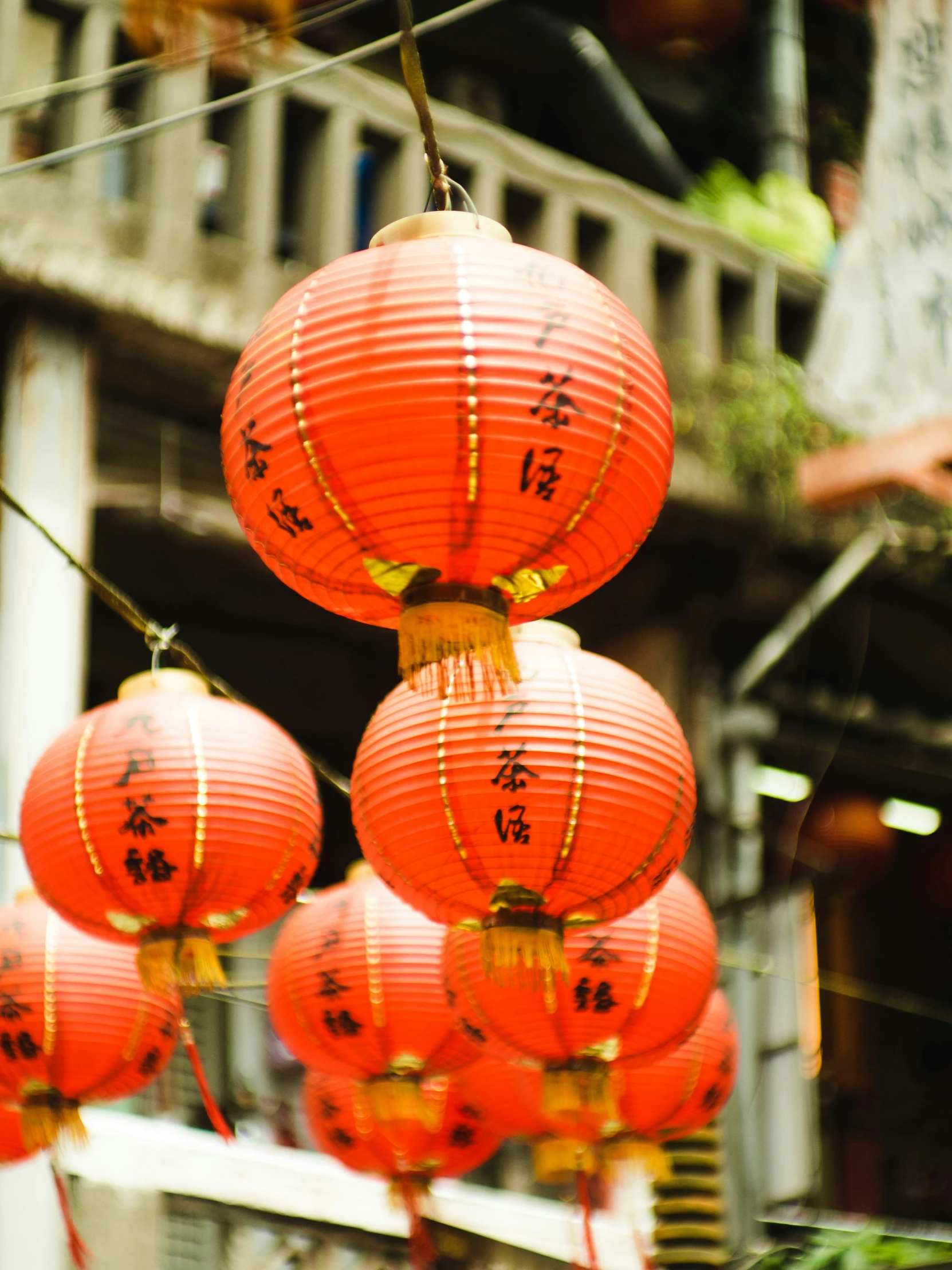 red lanterns are suspended in front of a building