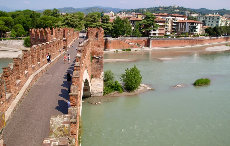 an old roman bridge with water surrounding it