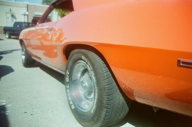 the back end of an orange car with the hood down