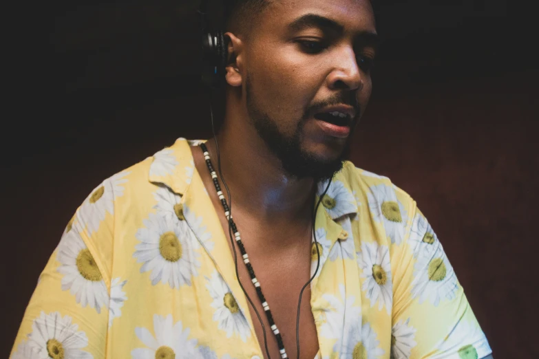 a man with a flower shirt on and pearls necklace