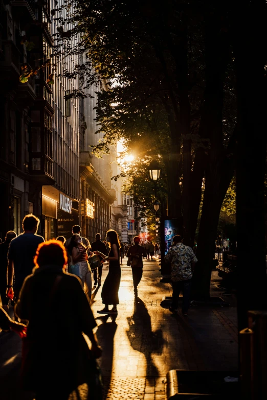 people walk down the sidewalk in the city at night