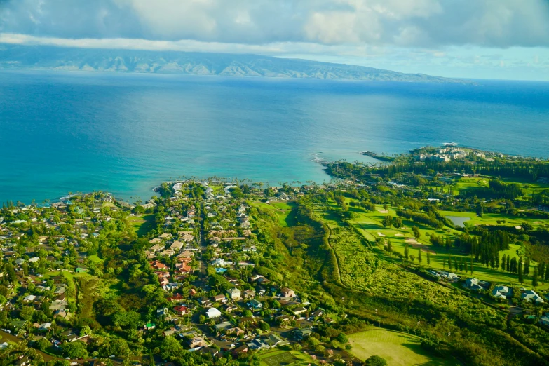 a view of a lush green field next to an ocean