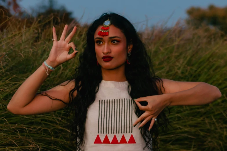 a girl wearing a red head piece with a peace sign in her hand