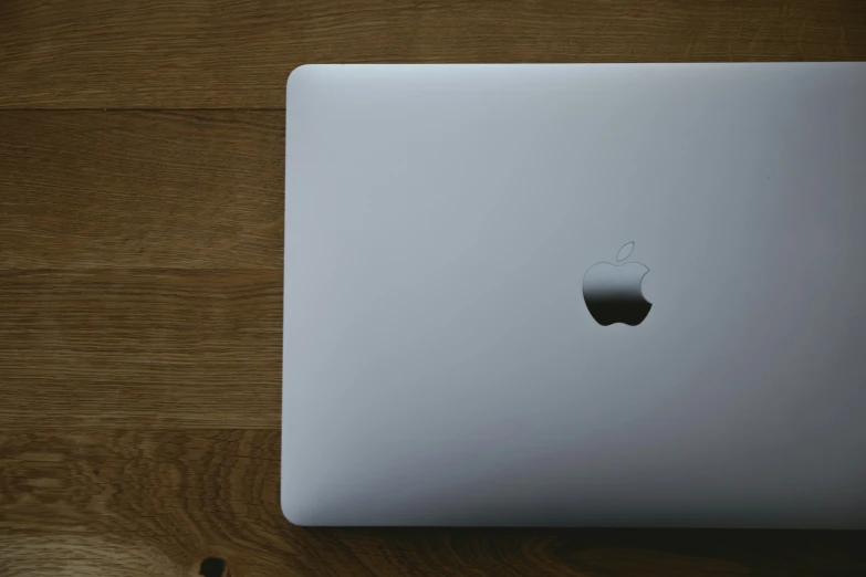 apple computer laptop sitting on wooden table top