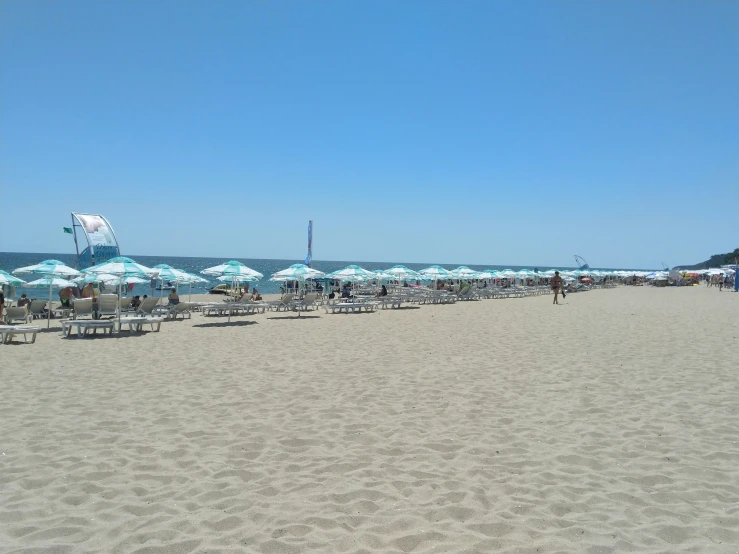 many beach chairs with umbrellas that are all over them