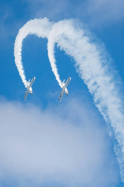 the two airplanes are flying very close together in the sky