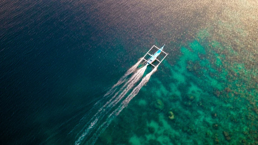 a small boat sailing in the ocean water