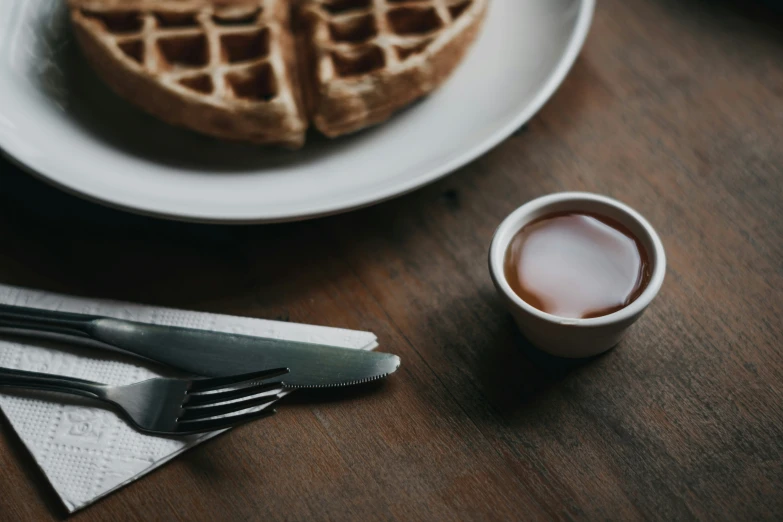 a couple of waffles sitting on a plate next to some silverware