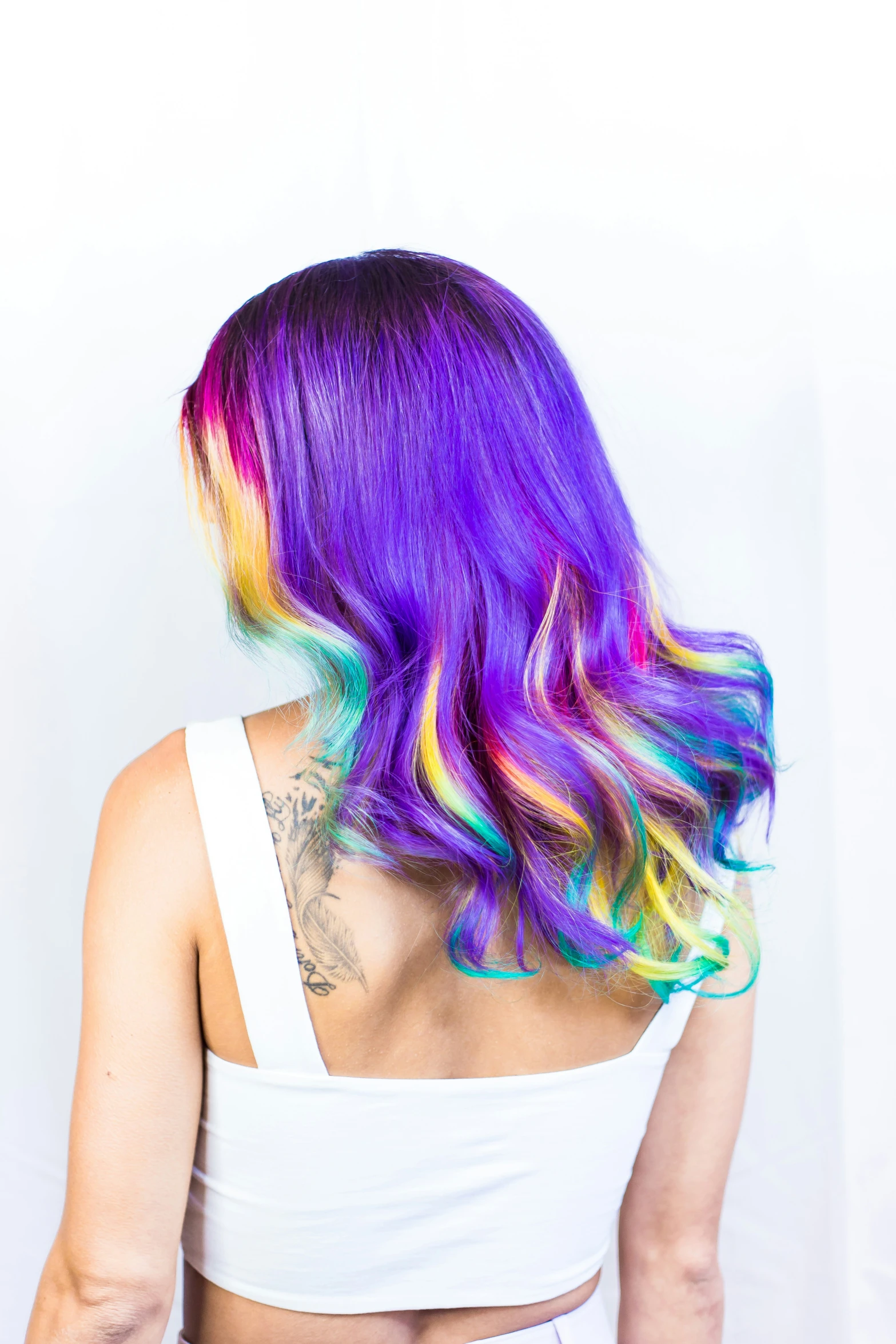 the back of a woman with bright rainbow hair