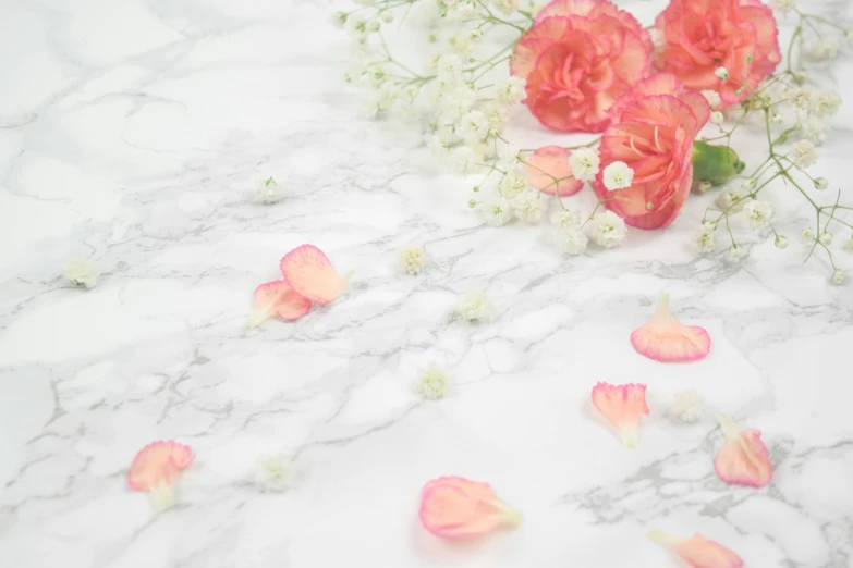 some flowers sitting on top of a white and gray marble surface