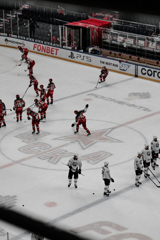 an ice hockey game in progress with players dressed in red and black playing