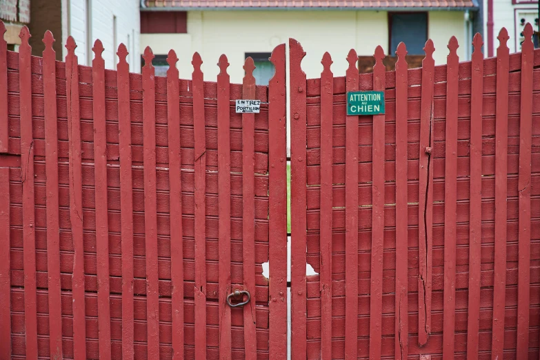 an orange picket fence with a green street sign