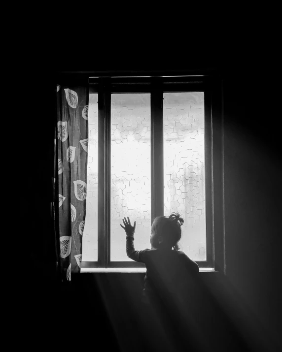 a woman reaching out for the sun through a window