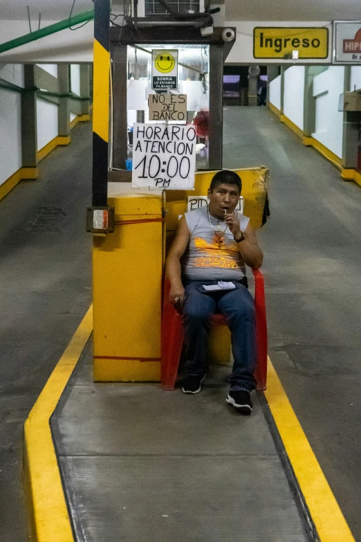 a person sitting on a red chair in a subway