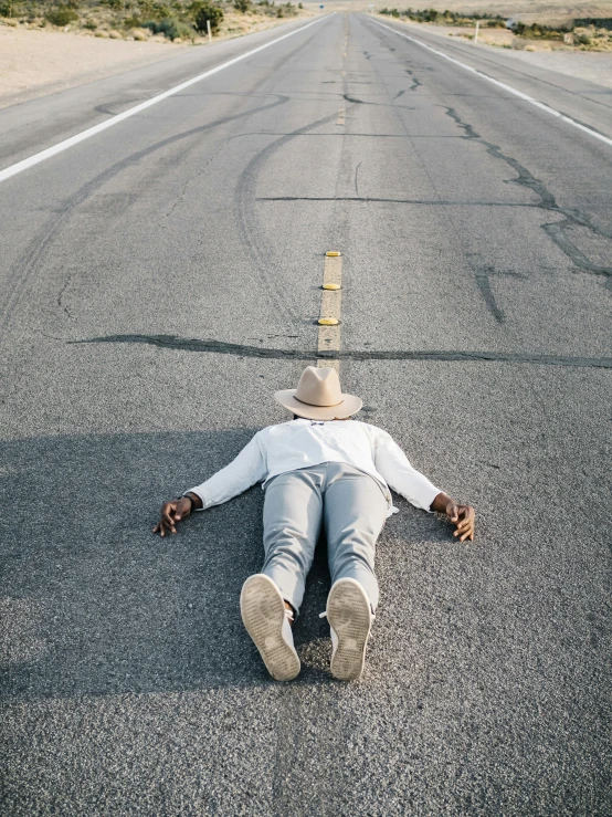 a man laying on the street while taking a nap