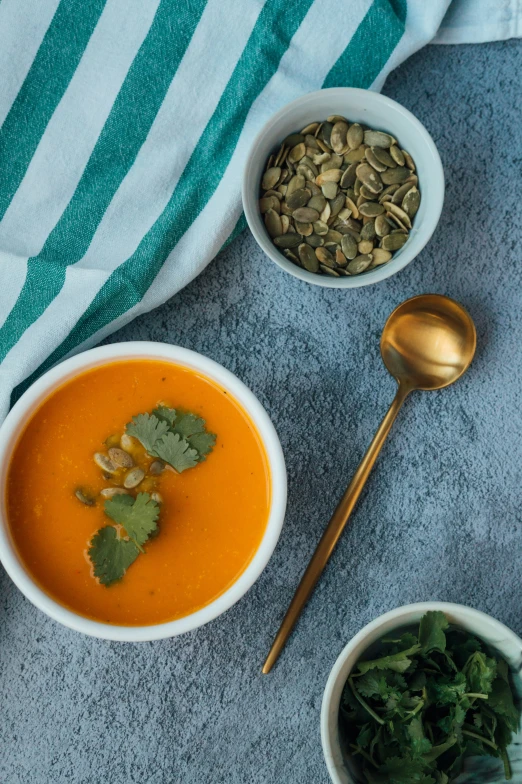 bowls of soup on a table and a spoon