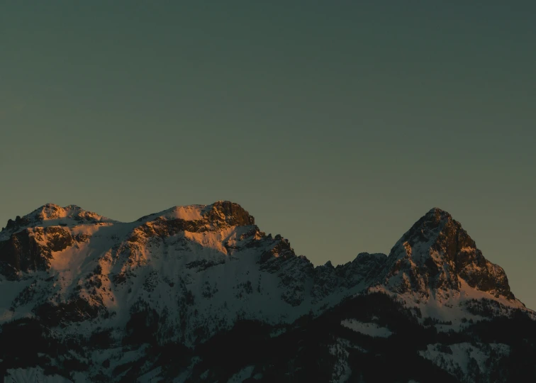 a mountain with snow on the top and the sky above