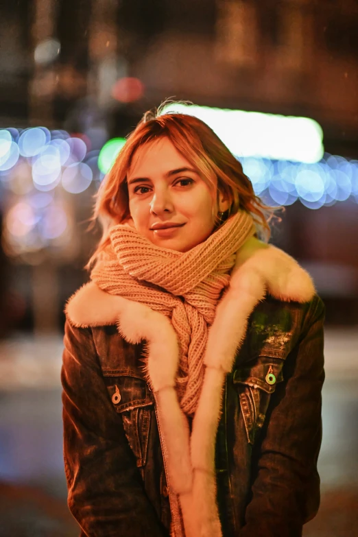 a young woman smiles while wearing a scarf and jacket