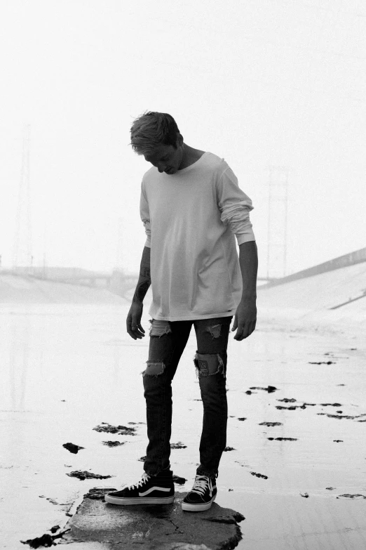 a man standing on a beach with his surfboard